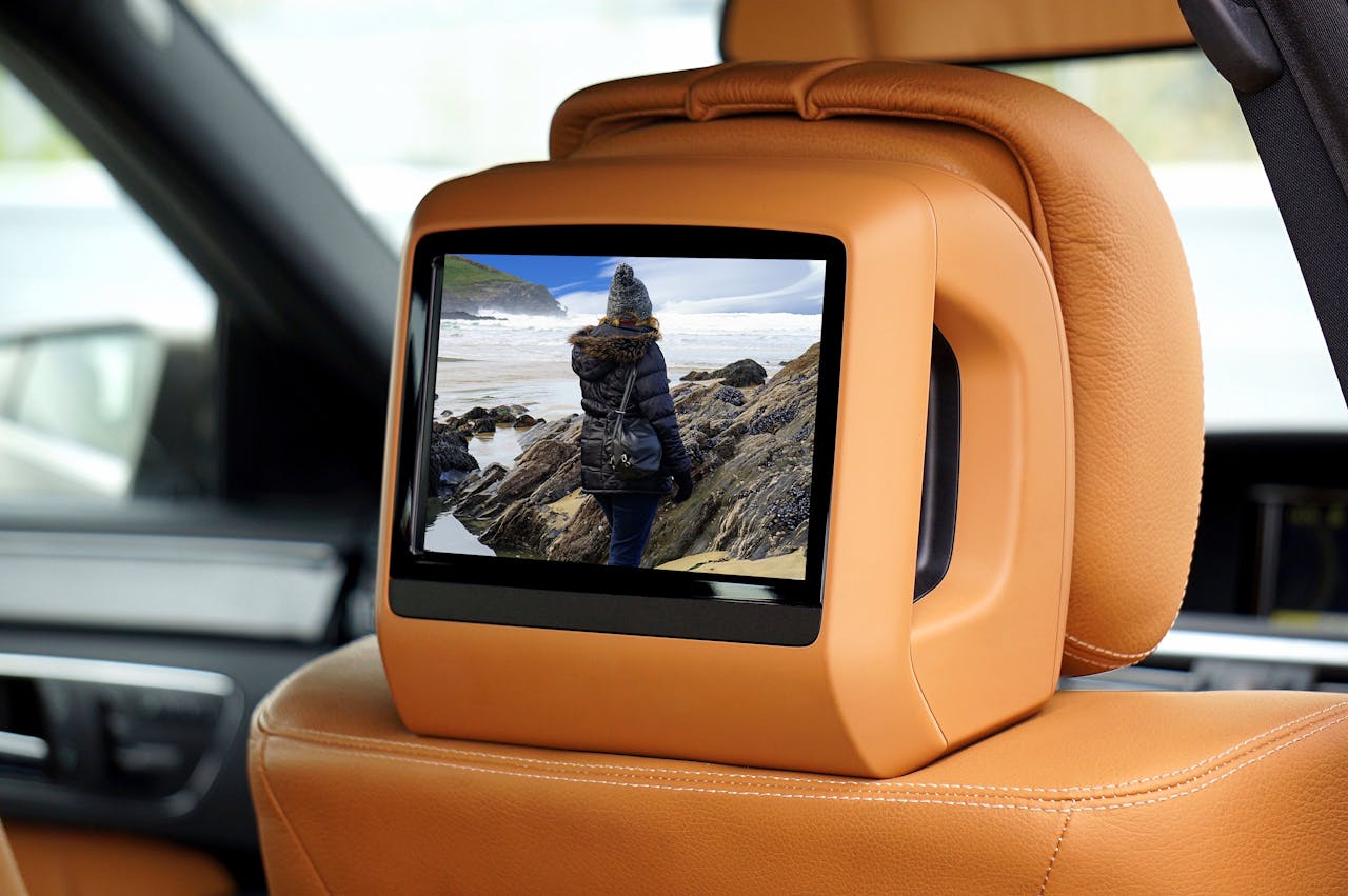 about-us A luxury car interior showcasing a built-in screen displaying scenic landscape.